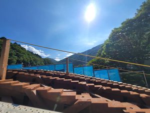 長野県の木造アーチ橋修復現場で撮影された、階段状に精密に刻まれた木製の桁材（桁の刻み）